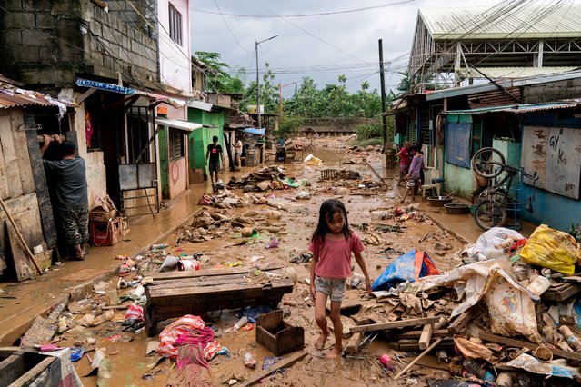 A girl walks past the debris and mud following the floods brought by Typhoon Gaemi, in Marikina City, Metro Manila, Philippines, on July 25, 2024. (Photo by Lisa Marie David/Reuters)