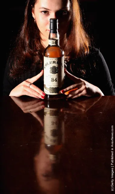 Victoria Kasperovich, an employee at McTear's Auctioneers, views a bottle of Coleraine Single Malt Old Irish whiskey