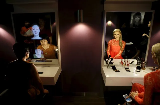 A woman looks at a mirror next to the wax figure of Paris Hilton at Grevin Wax Museum in central Seoul, South Korea, July 30, 2015. (Photo by Kim Hong-Ji/Reuters)