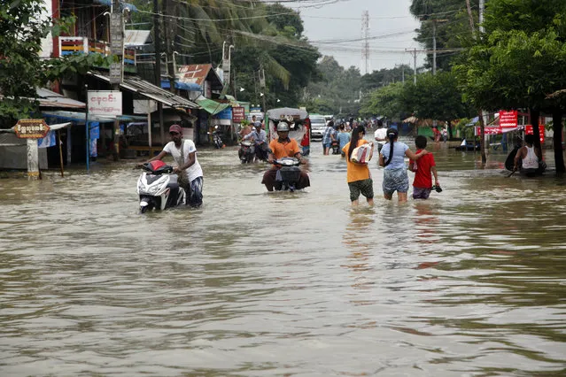 Local residents wade through a flooded road in Bago, 80 kilometers (50 miles) northeast of Yangon, Myanmar, Saturday, August 1, 2015. Myanmar's president has declared several regions of the country to be disaster zones, as forecasts of heavy rain for the next few days have heightened fears that already dire flooding in many parts of the country will get worse. (Photo by Khin Maung Win/AP Photo)