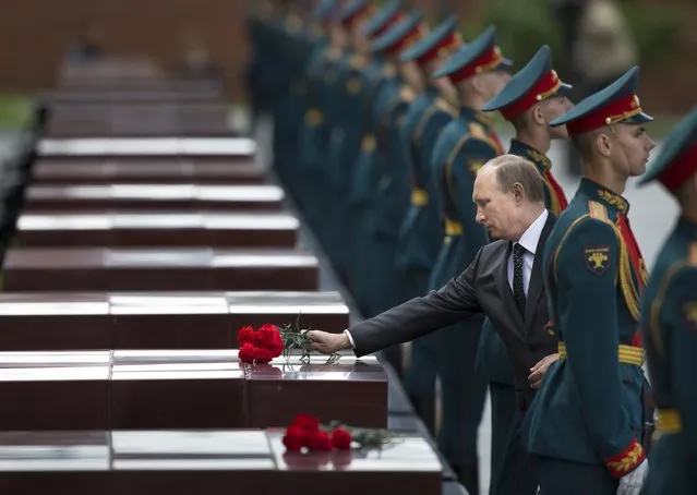 Russian Vladimir Putin, second right, takes part in a wreath laying ceremony at the Tomb of the Unknown Soldier outside Moscow's Kremlin Wall, in Moscow, Russia, Sunday, June 22, 2014,  to mark the 73rd anniversary of the Nazi invasion of the Soviet Union. (Photo by Alexander Zemlianichenko/AP Photo)