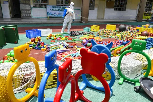 A staff member sprays disinfectant to halt the spread of the Covid-19 coronavirus at a primary school on May 6, 2022 in Dongguan, Guangdong Province of China. (Photo by Zhan Youbing/VCG via Getty Images)
