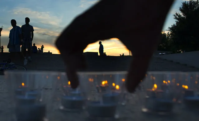 The scene as people light candles to form the letters into the words, “So All Can Vote” to support Voting Rights during a vigil on June 24, 2014 in Washington, DC. The vigil was a memorial to Andrew Goodman, James Chaney and Michael Schwerner, who were killed in 1964 by the KKK in Mississippi. The vigil included a display of 3,000 candles at the base of the Lincoln Memorial near the reflecting pool. Bend the Arc: A Jewish Partnership for Justice organization sponsored the memorial event on the 50th anniversary of their  activist murders. (Photo by Michel du Cille/The Washington Post)