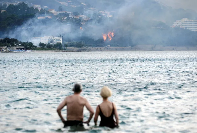 People look on as fires break out in Cefalù near Palermo, southern Italy, June 16, 2016. (Photo by Guglielmo Mangiapane/Reuters)