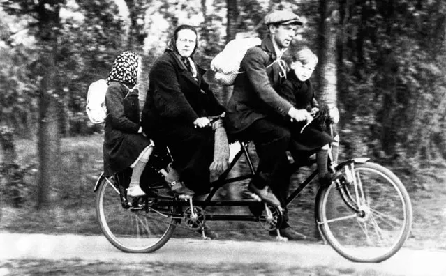 It is a bicycle built for two but the whole family and some spare clothing are aboard as Mama and Papa, pedal through Belgium ahead of the German army in Belgium, June 2, 1940. (Photo by AP Photo)