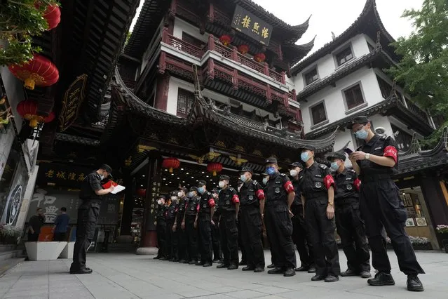 Security guards prepare for duty at the Yu Garden Mall, Thursday, June 2, 2022, in Shanghai. (Photo by Ng Han Guan/AP Photo)