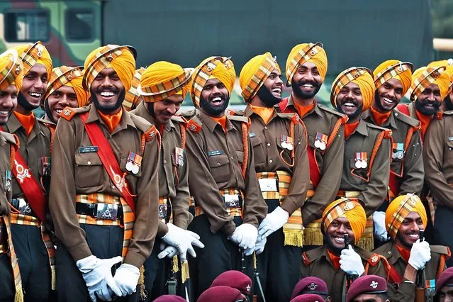 Indian army soldiers share a light moment as they wait to perform during rehearsals for the upcoming Republic Day parade at Raisina Hills, the government seat of power, in New Delhi, India, Monday, January 20, 2020. India celebrates Republic Day on Jan. 26, highlighted by a march past by different branches of the military as well as a display of arms and missiles. (Photo by Manish Swarup/AP Photo)