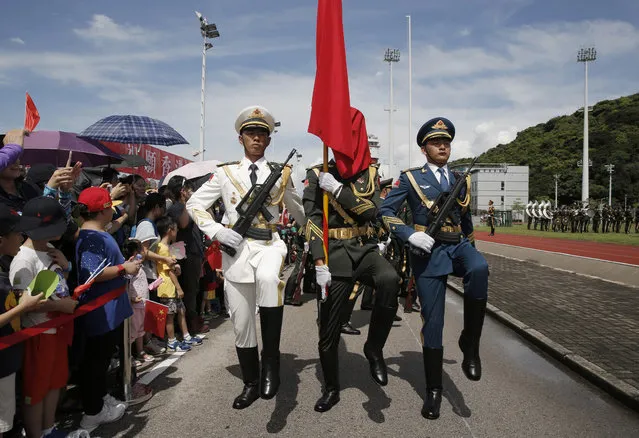 Chinese People's Liberation Army (PLA) soldiers march as they take part in a flag raising ceremony during the open day of Stonecutter Island Navy Base in Hong Kong to mark the 19th anniversary of the Hong Kong handover to China, Friday, July 1, 2016. (Photo by Kin Cheung/AP Photo)