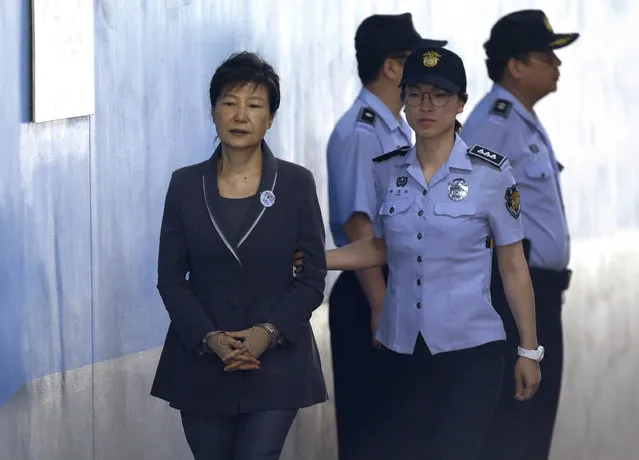 Former South Korean President Park Geun-hye, left, arrives for her trial at the Seoul Central District Court in Seoul, Monday, August 7, 2017. Lee Jae-yong, vice chairman of Samsung Electronics Co.,was indicted in February on charges including offering $38 million in bribes to a friend of then-President Park to seek government help in a merger that strengthened his control over Samsung. Park was removed from office and is being tried separately. (Photo by Ahn Young-joon/AP Photo).