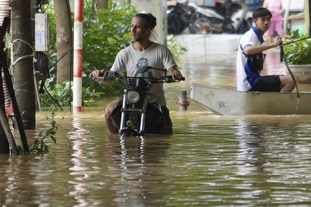 A man pushes his motorbike in a flooded street in the aftermath of Typhoon Yagi, in Hanoi, Vietnam on Thursday, September 12, 2024. (Phoot by Hau Dinh/AP Photo)