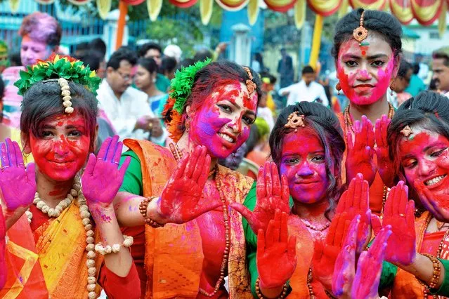 Revellers smeared in colour powder pose for a picture as they celebrate Holi, the spring festival of colours, in Siliguri on March 9, 2020. (Photo by Diptendu Dutta/AFP Photo)