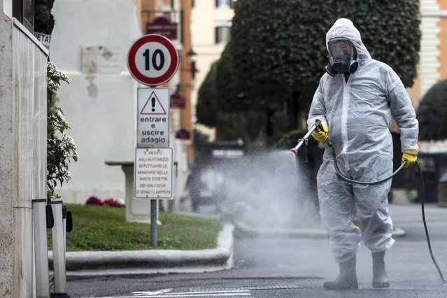 A man carries out sanitization operations at a neighborhood during the emergency lockdown due to the Covid-19 Coronavirus outbreak in Rome, Italy, 14 March 2020. (Photo by Angelo Carconi/EPA/EFE)