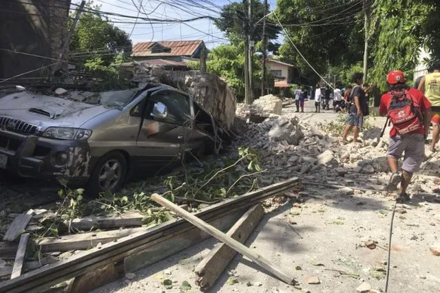 In this handout photo provided by the Philippine Red Cross, a vehicle is damaged as a wall collapses after a strong earthquake hit Ilocos Sur province, Philippines on Wednesday July 27, 2022. A strong earthquake shook the northern Philippines on Wednesday, causing some damage and prompting people to flee buildings in the capital. Officials said no casualties were immediately reported. (Photo by Philippine Red Cross via AP Photo)