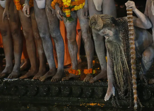 Naked Hindu holy men wait to bath in the Godavari River during Kumbh Mela, or Pitcher Festival, at Trimbakeshwar in Nasik, India, Saturday, August 29, 2015. Hindus believe taking a dip in the waters of a holy river during the festival, will cleanse them of their sins.  According to Hindu mythology, the Kumbh Mela celebrates the victory of gods over demons in a furious battle over a nectar that would give them immortality. (Photo by Rajanish Kakade/AP Photo)