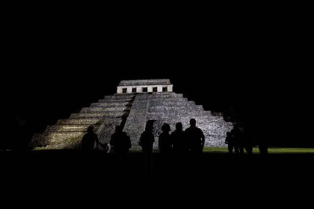 In this March 10, 2008 file photo, journalists appear silhouetted against a Mayan temple, before covering the meeting of 'Indigenous People to Heal Our Mother Earth'' in Palenque, Mexico. Archaeologists at Palenque have discovered an underground water tunnel built under the Temple of Inscriptions, which houses the tomb of Mayan ruler Pakal. Archaeologists believe the tunnels were built to give Pakal's spirit a path to the underworld. (Photo by Alexandre Meneghini/AP Photo)
