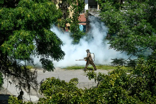 A worker sprays disinfectant in a residential area during a government-imposed nationwide lockdown as a preventive measure against the COVID-19 coronavirus, in Islamabad on April 10, 2020. (Photo by Aamir Qureshi/AFP Photo)