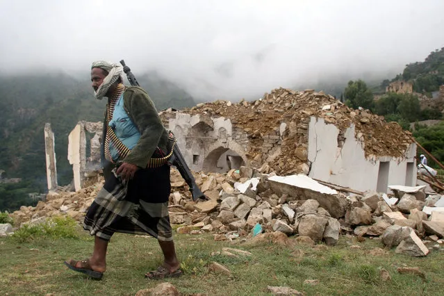 A pro-government fighter walks past a mosque, destroyed during fighting between pro-government forces and Iran-allied Houthi militia, in the al-Sarari area of Taiz province, Yemen July 28, 2016. (Photo by Anees Mahyoub/Reuters)
