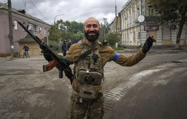 Ukrainian paratrooper Andrii Bashtovyi reacts as he see his comrades in the recently retaken area of Izium, Ukraine, Wednesday, September 14, 2022. (Photo by Evgeniy Maloletka/AP Photo)