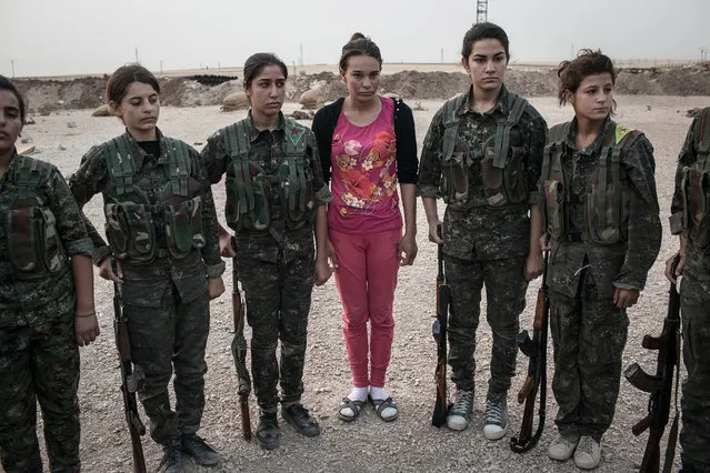 A young YPJ recruit (in pink) arrives to the training base for her first day in training near Derek City, Syria. The YPJ schedule is demanding and requires discipline – new soldiers in training get about 6 hours of sleep a night and wake up at 4 AM to begin exercising; afterwards, their day consists of a full schedule of drills and classroom lessons. Before joining the YPJ many of the girls had never participated in physical activity or sports before. (Photo by Erin Trieb/NBC News)