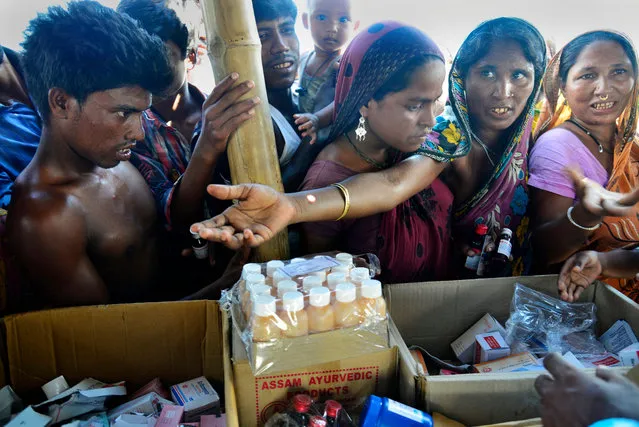 A picture made available on 03 August 2016 shows flood affected people collect medicine during a medical camp organised by officials from the Jhargaon Public Health Engendering (PHE) organization in the flood affected Gagolmari area in Morigaon district of Assam state, India, 02 August 2016. According to media reports twelve people have died so far and more than 1.6 million people of the 19 districts in Assam state have been affected by the current floods. (EPA/Stringer)