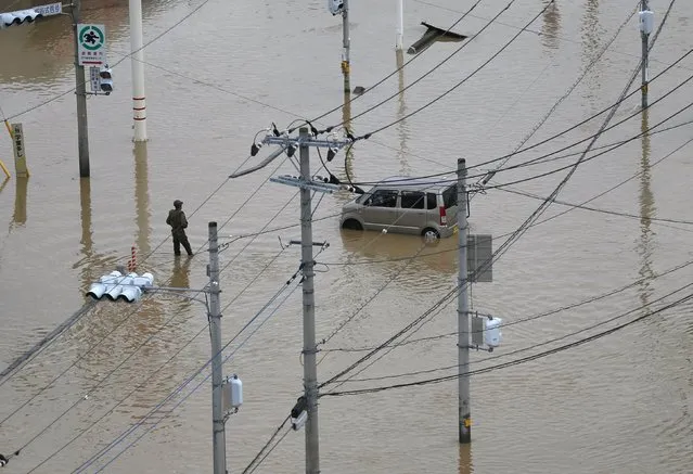 A damaged car is seen at a residential area flooded by the Kinugawa river, caused by typhoon Etau, in Joso, Ibaraki prefecture, Japan, September 11, 2015. (Photo by Issei Kato/Reuters)