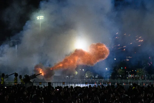 Artillery guns are fired near the cremation grounds where the body of the late Thai King Bhumibol Adulyadej was taken to be cremated after his funeral procession in Bangkok on October 26, 2017. A sea of black-clad mourners massed across Bangkok's historic heart early on October 26 as funeral rituals began for King Bhumibol Adulyadej, a revered monarch whose passing after a seven-decade reign has left Thailand bereft of its only unifying figure. (Photo by Anthony Wallace/AFP Photo)