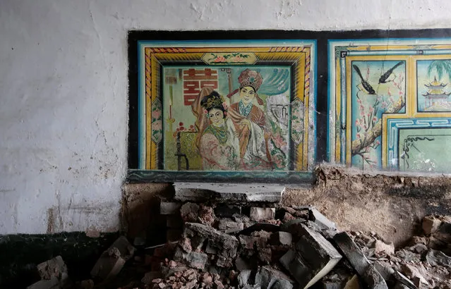 Paintings are seen on a damaged wall inside an abandoned cave house in an area where land is sinking next to a coal mine, in the deserted Liuguanzhuang village of Datong, China's Shanxi province, August 1, 2016. (Photo by Jason Lee/Reuters)