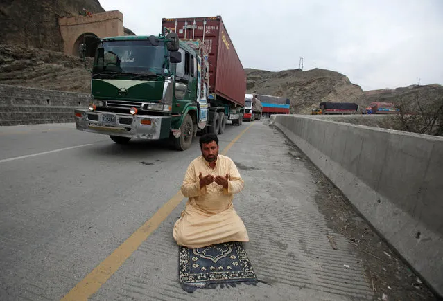 A truck driver offers afternoon prayers near his supply truck, after the opening of Pakistan Afghan Torkham border, in Landi Kotal, Pakistan March 21, 2017. (Photo by Fayaz Aziz/Reuters)