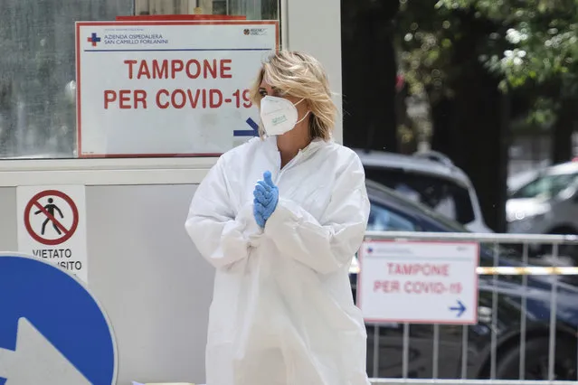 A medical staffer stands by a sign reading swab for COVID-19 in Rome, Tuesday, June 9, 2020, after a cluster of two dozen more cases at San Raffaele Pisana hospital that has been sealed off to contain the spread. Last Saturday, regional health authorities in Rome reported new cases at the San Raffaele Pisana hospital, a 298-bed clinic in the capital that specializes in neurological rehabilitation and Parkinson’s research. (Photo by Mauro Scrobogna/LaPresse via AP Photo)