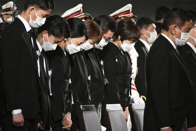 Akie Abe, sixth left, the widow of former Japanese Prime Minister Shinzo Abe, bows her head with others for a moment of silence during his state funeral at the Nippon Budokan in Tokyo Tuesday, September 27, 2022. (Photo by Philip Fong/Pool Photo via AP Photo)