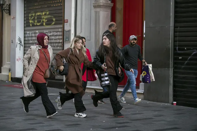 People leave the area after an explosion on Istanbul's popular pedestrian Istiklal Avenue Sunday, Istanbul, Sunday, November 13, 2022. A bomb exploded on a major pedestrian avenue in the heart of Istanbul on Sunday, killing six people, wounding dozens and sending people fleeing as flames rose. (Photo by Can Ozer/AP Photo)