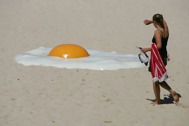 A woman approaches an artwork called “Big Chook”, made of fibreglass and high gloss epoxy marine paint, by Australian artist Jeremy Parnell on Tamarama Beach in Sydney November 2, 2005. (Photo by Will Burgess/Reuters)