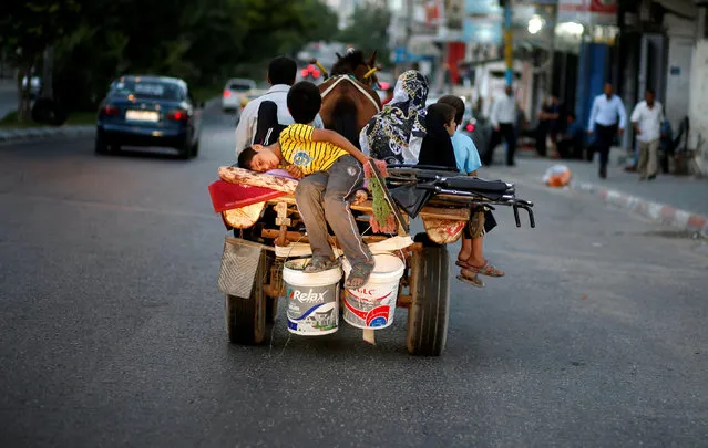 A Palestinian boy sleeps as he rides a horse-drawn cart with his family on a street in Gaza City July 22, 2016. (Photo by Mohammed Salem/Reuters)