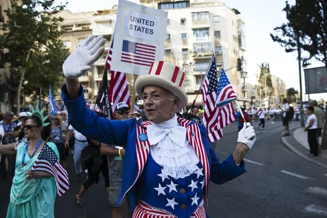A participant waves an American flag during an annual parade on the Jewish holiday of Sukkot in Jerusalem October 1, 2015. (Photo by Ronen Zvulun/Reuters)