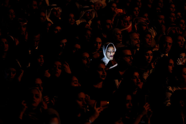Light from a mobile phone illuminates a Saudi woman's face during Iraqi singer Majid Al Muhandis' live performance as part of Spring of Culture 2017 in Manama, Bahrain, March 10, 2017. (Photo by Hamad I Mohammed/Reuters)