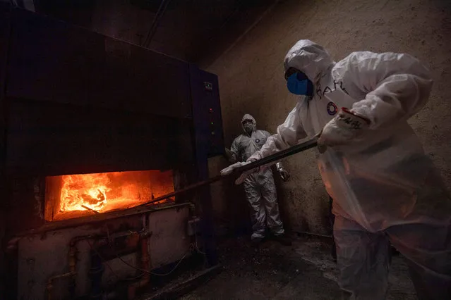 Employees wear protective gear while working at the Azcapotzalco crematorium in Mexico City, on August 6, 2020, amid the COVID-19 coronavirus pandemic (Photo by Pedro Pardo/AFP Photo)