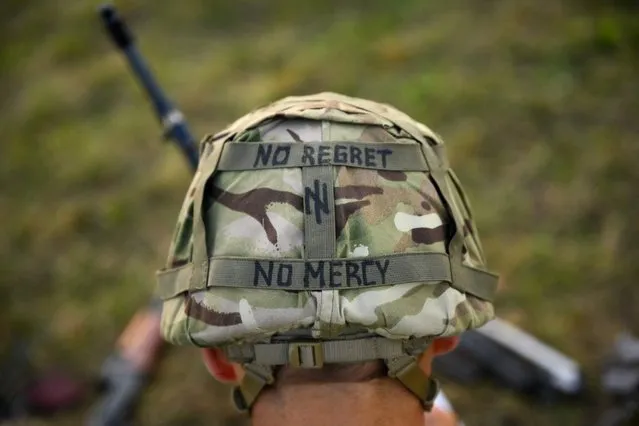 A slogan is seen painted on a helmet of Ukrainian recruit during a five-week combat training course with the UK armed forces near Durrington in southern England on October 11, 2022. Ukrainian soldiers charge across a plain, brandishing rifles as smoke drifts from an explosion. But the recent recruits are not on the front line back home. They are in Britain, where the army is helping them to learn vital battlefield skills. (Photo by Daniel Leal/AFP Photo)