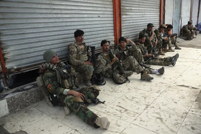 Afghan security personnels rest in front of a prison after an attack in the city of Jalalabad, east of Kabul, Afghanistan, Monday, August 3, 2020. An Islamic State group attack on the prison in eastern Afghanistan holding hundreds of its members raged on Monday after killing people in fighting overnight, a local official said. (Photo by Rahmat Gul/AP Photo)