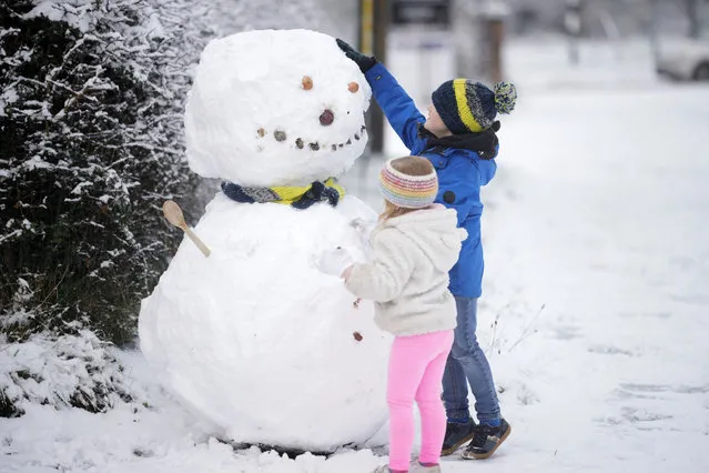 Children build a snowman after the first significant snow fall in Cheshire this Winter on December 10, 2022 in Northwich, United Kingdom. The UK Health Security Agency (UKHSA) issued a cold-weather alert that will run until Monday morning, as many across the UK struggle with home-heating costs. (Photo by Christopher Furlong/Getty Images)