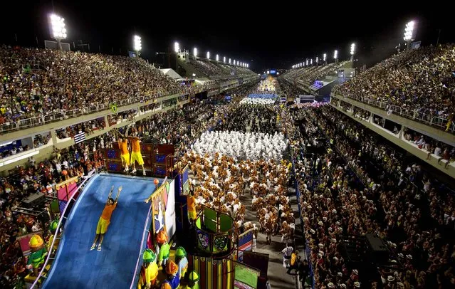 A performer from the Unidos da Tijuca samba school slides down a water ramp atop a float at the Sambadrome in Rio de Janeiro. (Photo by Felipe Dana/Associated Press)