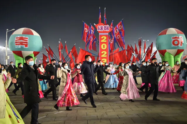 In this photo taken late on December 31, 2022, participants take part in a dancing party to celebrate the new year on Kim Il Sung Square in Pyongyang. (Photo by KIM Won Jin/AFP Photo)