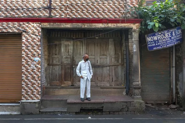 A man wearing a mask as protection against the coronavirus stands in front of a closed shop in Dharmsala, India, Wednesday, September 23, 2020. The nation of 1.3 billion people is expected to become the pandemic's worst-hit country within weeks, surpassing the United States. (Photo by Ashwini Bhatia/AP Photo)