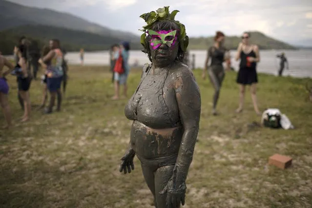 A mud covered reveler poses for a picture wearing a mask during the traditional “Bloco da Lama” or “Mud Block” carnival party in Paraty, Brazil, Saturday, February 10, 2018. (Photo by Leo Correa/AP Photo)
