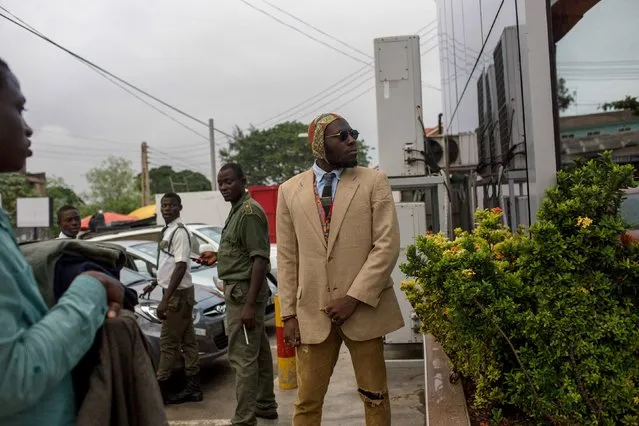 DJ Evans Mireku Kissi tries on a blazer being offered on sale by a street seller in Accra, Ghana, July 3, 2015. (Photo by Francis Kokoroko/Reuters)
