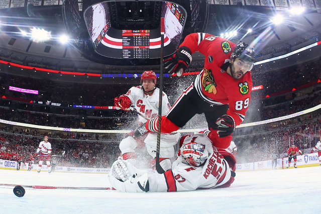 Andreas Athanasiou #89 of the Chicago Blackhawks is tripped by Pyotr Kochetkov #52 of the Carolina Hurricanes during the third period at the United Center on April 14, 2024 in Chicago, Illinois. (Photo by Michael Reaves/Getty Images/AFP Photo)