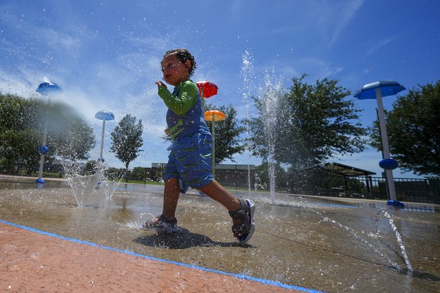Kamden McCoy cools off at a splash pad Wednesday, July 30, 2025, in Mansfield, Texas. (Photo by Julio Cortez/AP Photo)