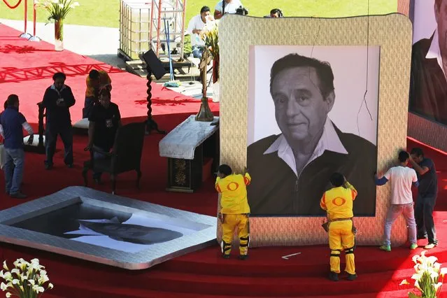 Workers hold up a giant photograph of the late screenwriter Roberto Gomez Bolanos, in preparation for a mass held in his memory at the Azteca stadium in Mexico City November 30, 2014. (Photo by Tomas Bravo/Reuters)