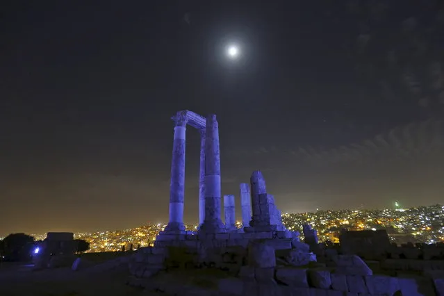 The moon is seen over the Roman pillars of the Temple of Hercules as it is lit up in blue to mark the 70th anniversary of the United Nations at the Citadel in Amman, Jordan, October 24, 2015. (Photo by Muhammad Hamed/Reuters)