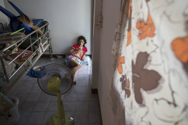 Arun Lunt, a practically blind AIDS patient, cools herself in front of a fan at the Buddhist temple Wat Prabat Nampu where she has been living for seven years in Lopburi province, north of Bangkok November 30, 2014. (Photo by Damir Sagolj/Reuters)