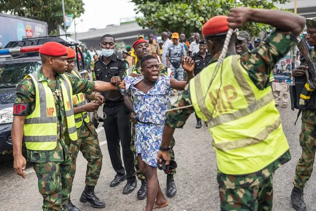 Members of the Nigerian Army Military Police detain with violence a man suspected of smoking illegal substances during a rally for the All Progressives Congress (APC) presidential candidate Bola Ahmed Tinubu at Teslim Balogun Stadium in Lagos on February 21, 2023 ahead of the Nigerian presidential election scheduled for February 25, 2023. (Photo by Michele Spatari/AFP Photo)